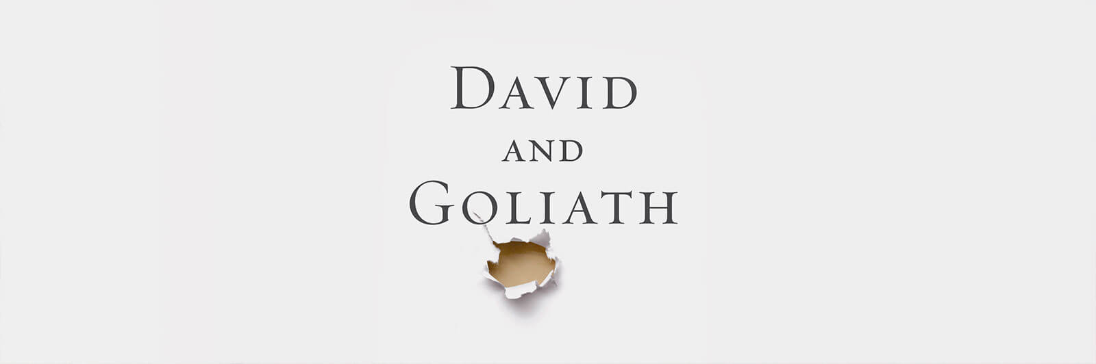 Hole punched through white paper below "David and Goliath" title