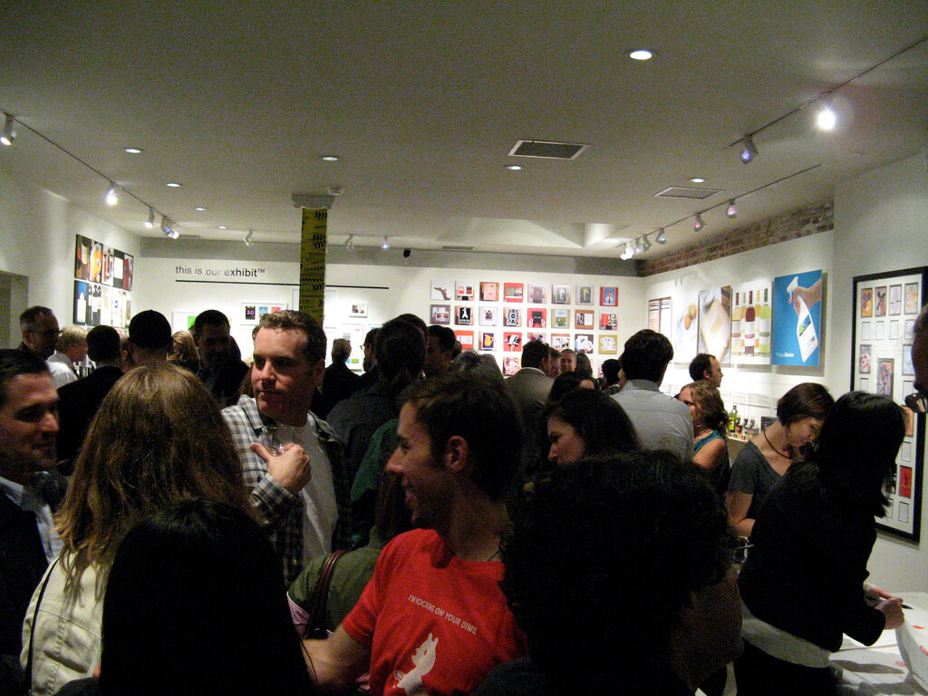 Crowded room at event with artwork on the walls