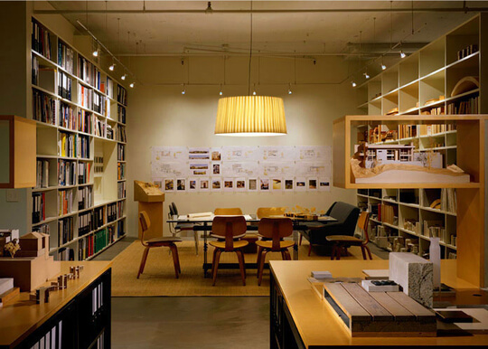 Room with book-filled shelves around table and chairs