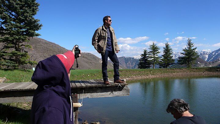 People preparing to photograph man standing outdoors on pier