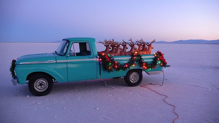 Christmas decorations on turquoise truck filled with fake reindeer