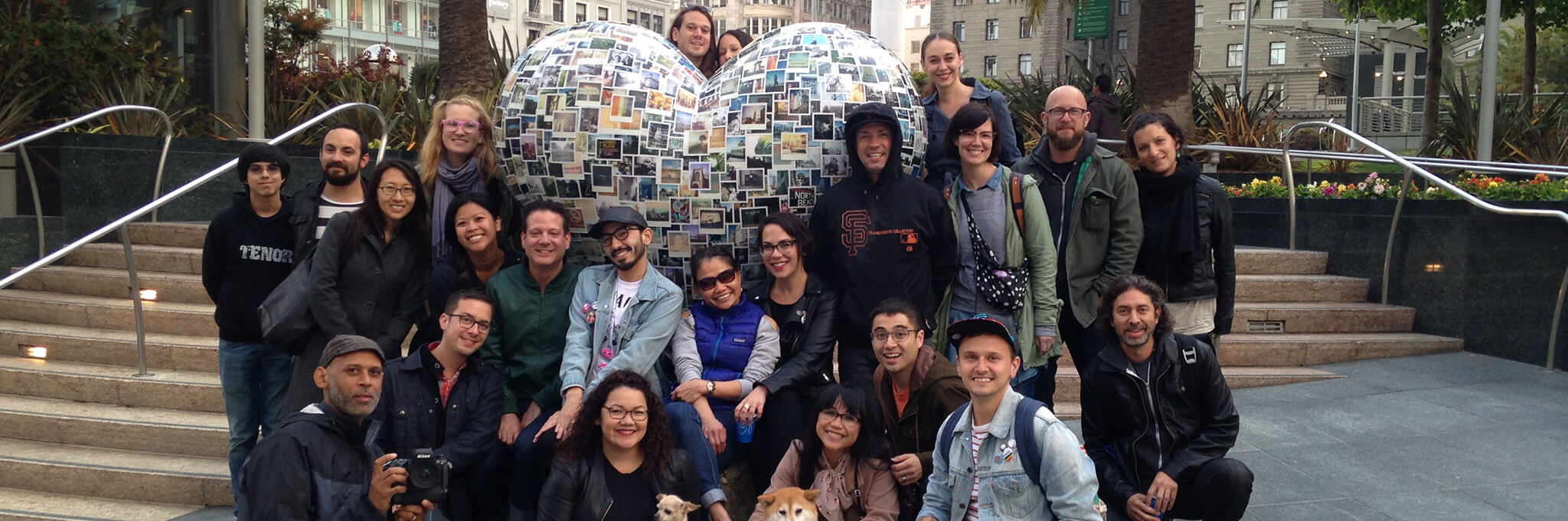 Group of people in front of polaroid-covered heart sculpture