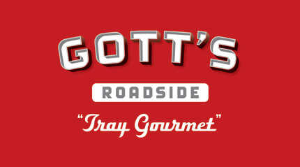 Silver and white Gott's Roadside logo with Tray Gourmet tagline on red background