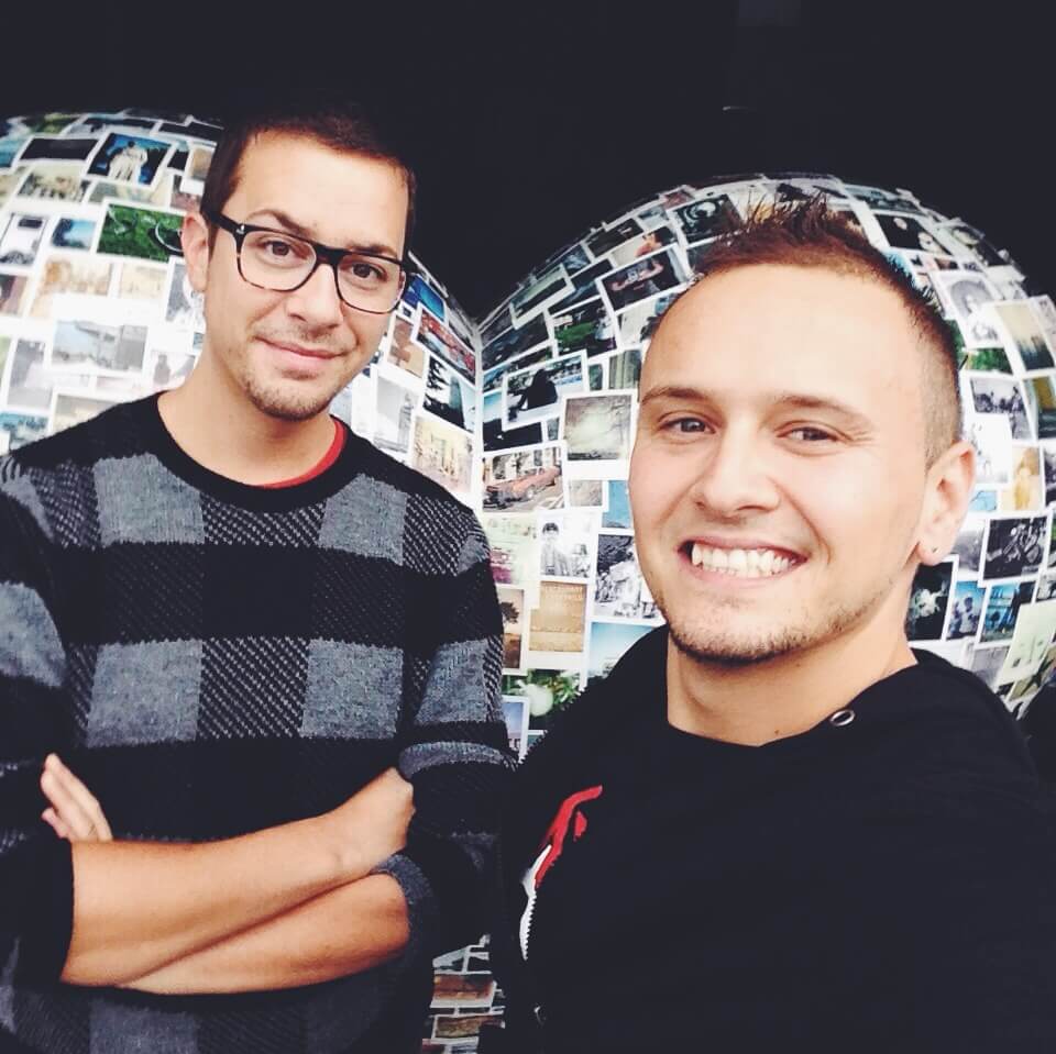 Bruce and Billy selfie in front of polaroid-covered heart sculpture