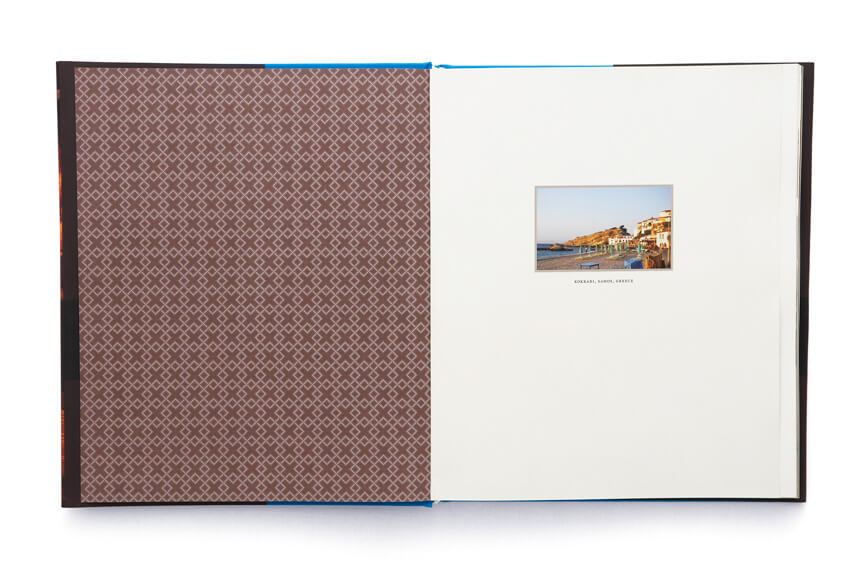 Open book showing brown and white pattern adjacent to page with small seaside photo