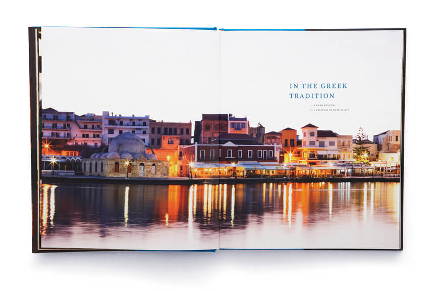 Open book showing seaside town of houses and buildings with reflections in the water