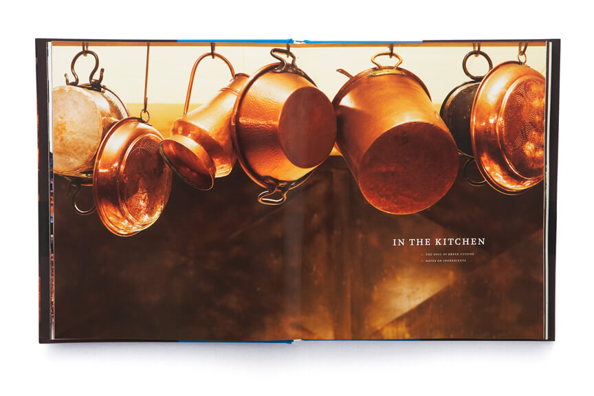 Open book showing copper pots and pans hanging from hooks