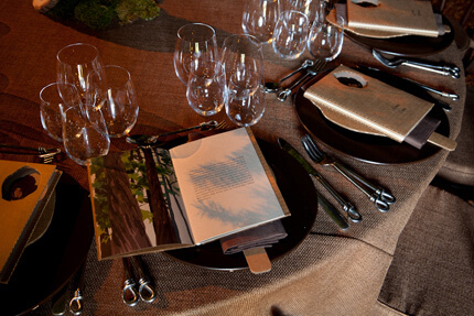 Table settings with glasses and program books on plates