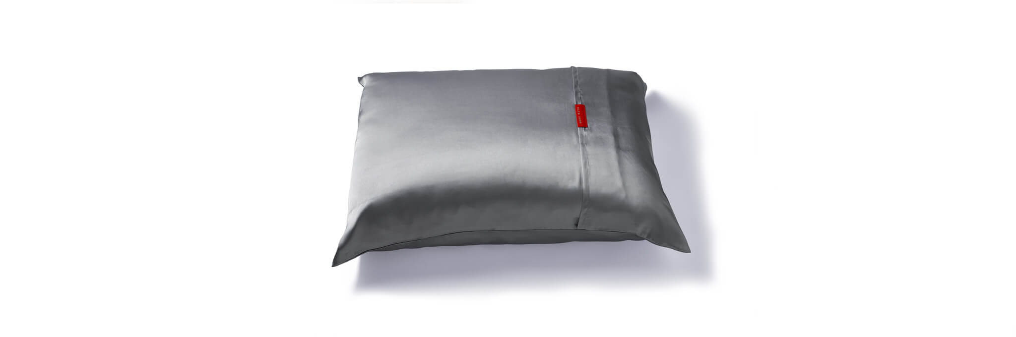 Silver pillow with red tag
